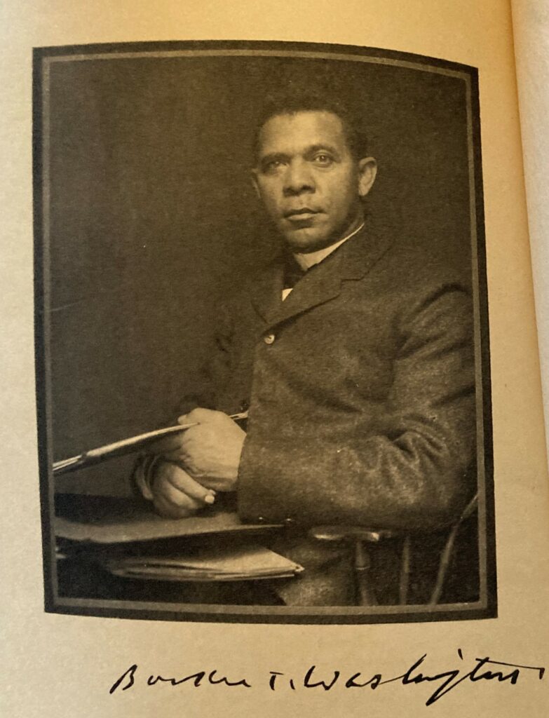 Black and white photo of African American man in a suit. Under photograph is signature.