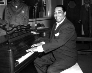 African American man smiling with hands on piano.