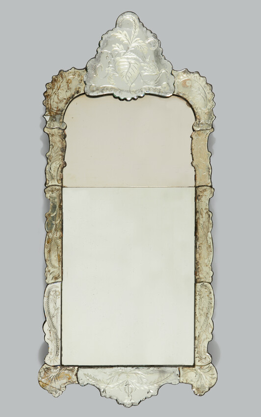 A photograph of an ornate mirror. It features a frame which is also made out of mirrored glass.